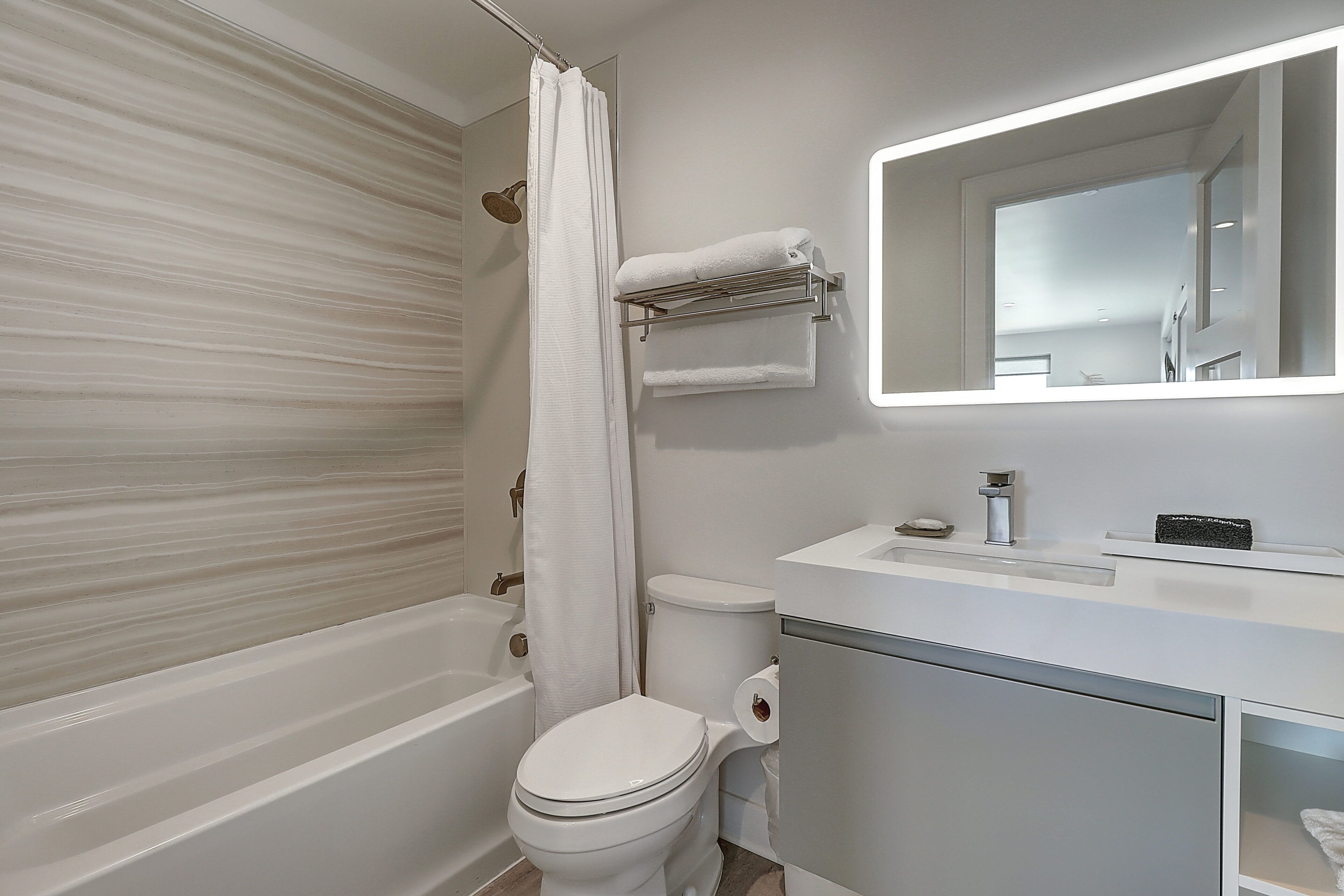 Ein modernes Badezimmer mit Badewanne, Toilette und Waschtisch.