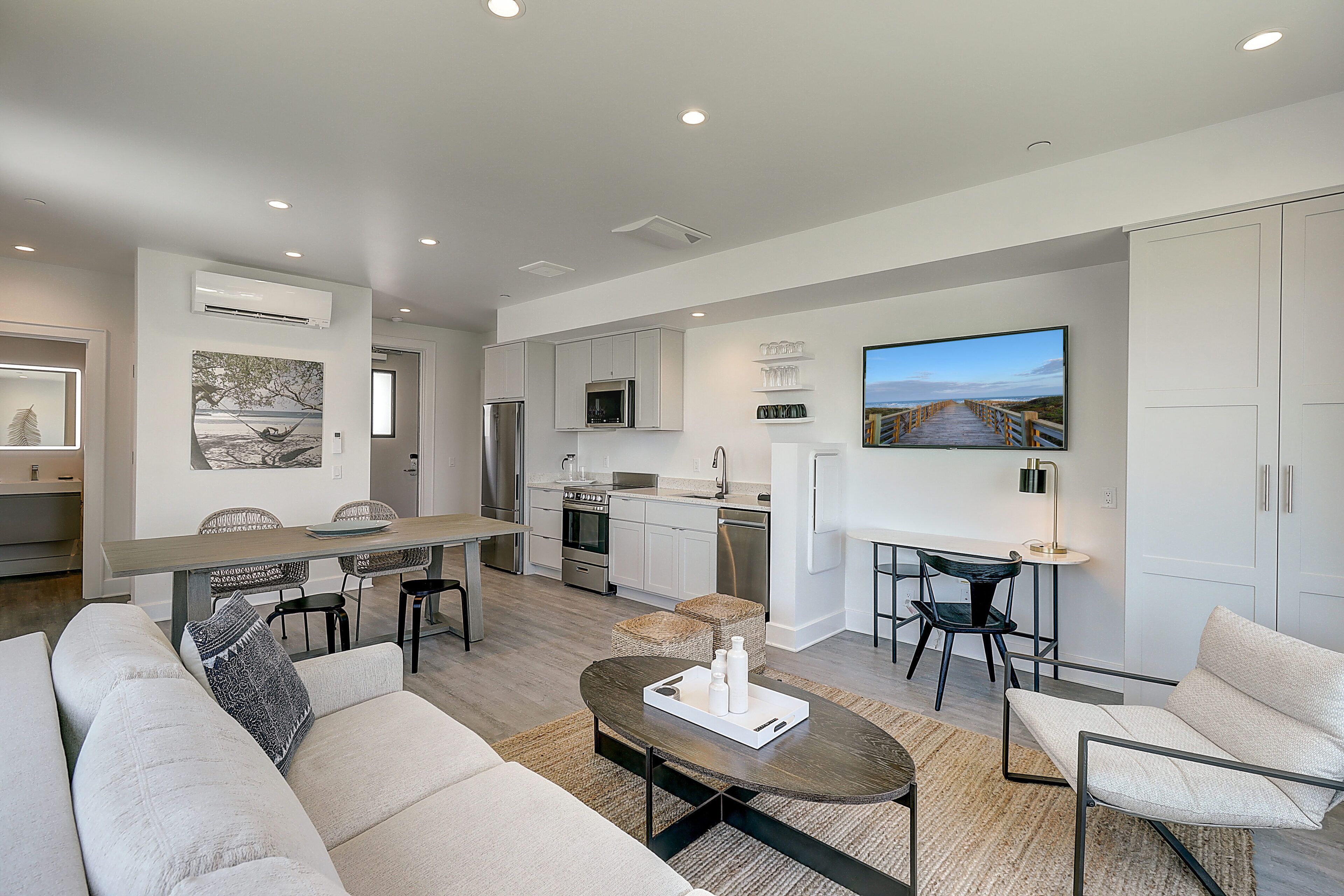 A modern living room with a sofa, coffee table, and dining area.