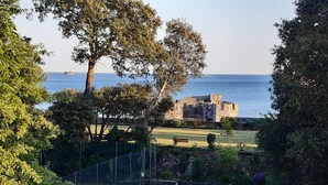 A grassy area with a picnic table, trees, and a stone building by the water. - The Mount,  2 ensuite double rooms by The Royal William Yard (Plymouth)