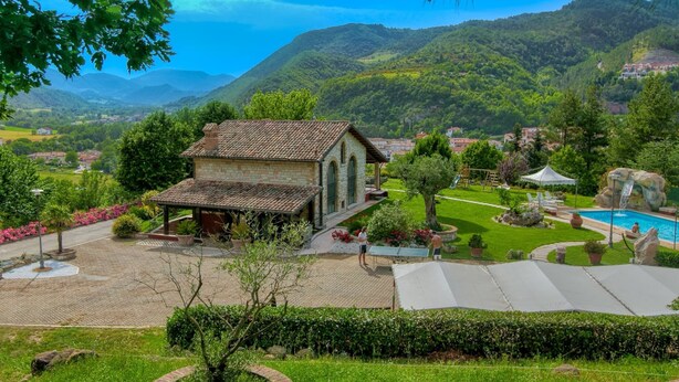 A stone house with a tiled roof, surrounded by a well-maintained lawn, a swimming pool, and a tennis court. - Family Cottage in Cagli With Pool (Cagli)