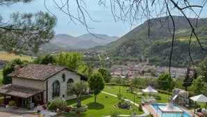 A villa with a swimming pool, garden, and views of a town and mountains. - Family Cottage in Cagli With Pool (Cagli)