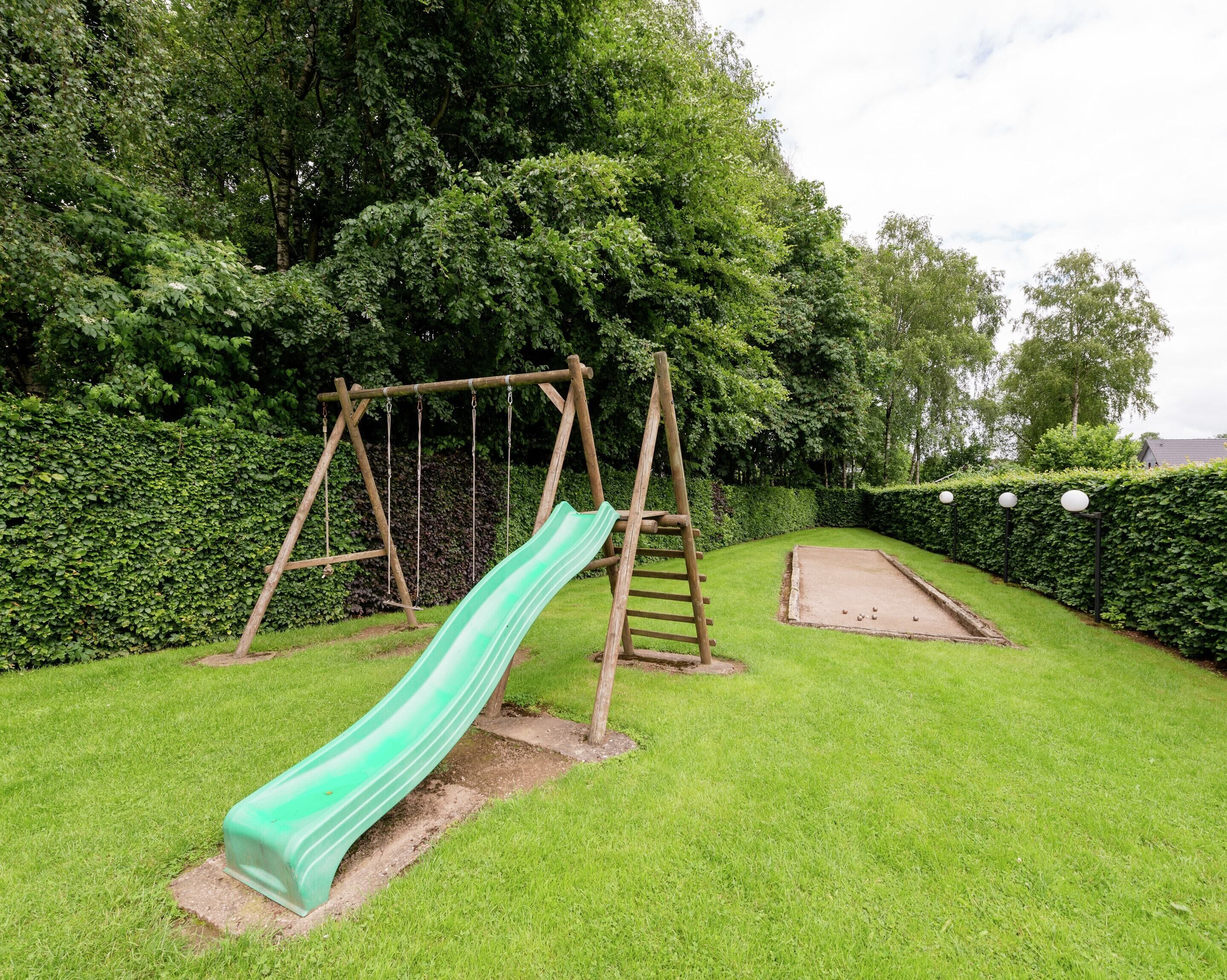 A playground with a slide, swings, and a croquet field.