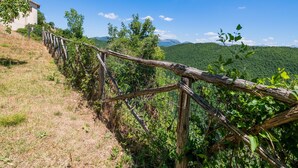 A wooden fence overlooking a lush green valley with distant mountains. - Belvilla by OYO Fonni Blu (Sellano)