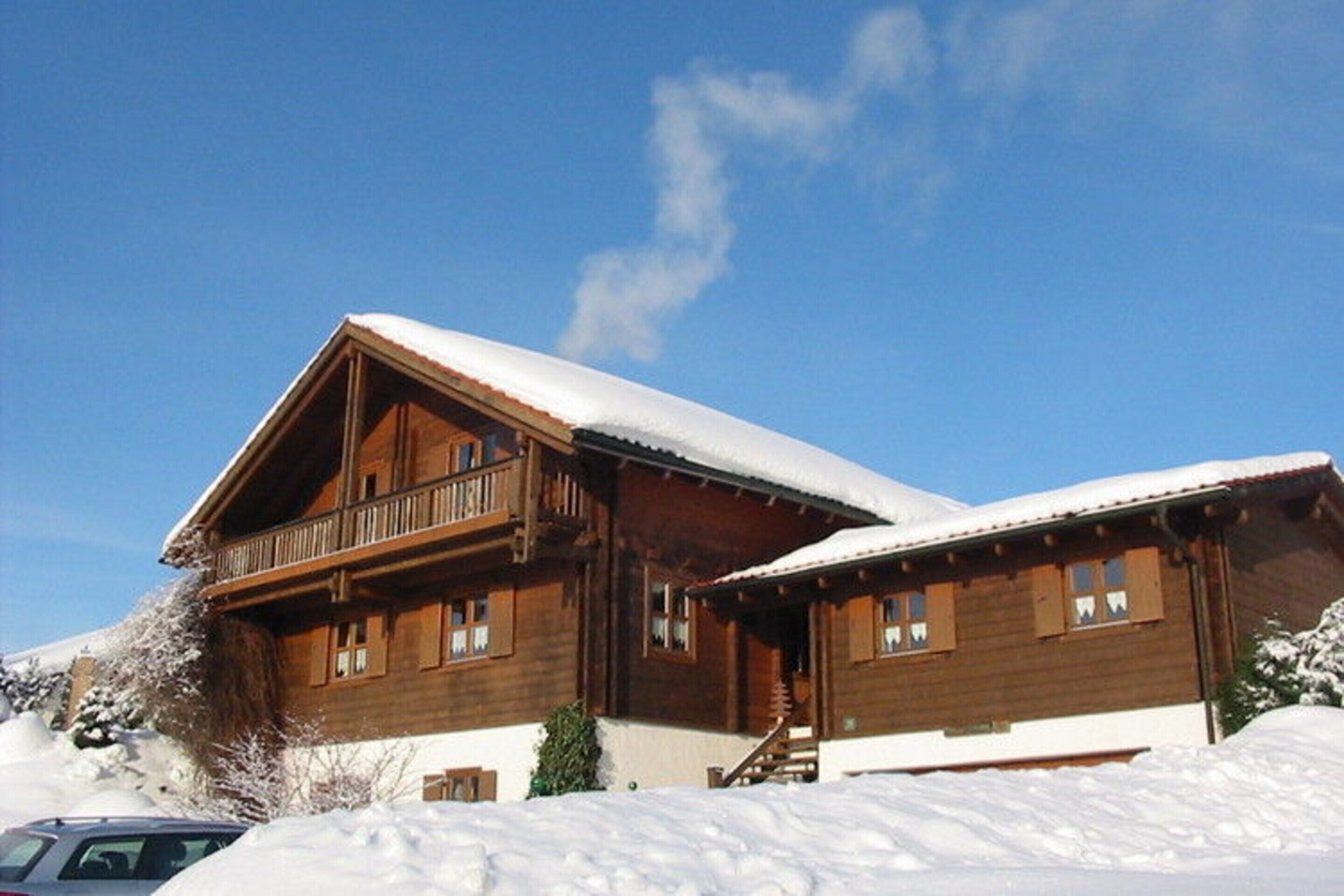 Eine Holzhütte mit Balkon, umgeben von Schnee.