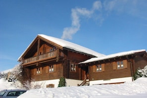 A wooden chalet with a balcony, surrounded by snow. - Wohnung in Bayerisch Eisenstein mit Garten (Bayerisch Eisenstein)