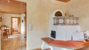 Una habitación acogedora con un banco de madera, una mesita pequeña y un adorno en la pared.