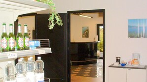 Un hall d’hôtel avec un comptoir d’accueil, des bouteilles d’eau et une machine à café.