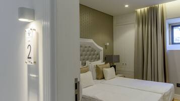 A hotel room with a large bed, a wardrobe, and a window with curtains.