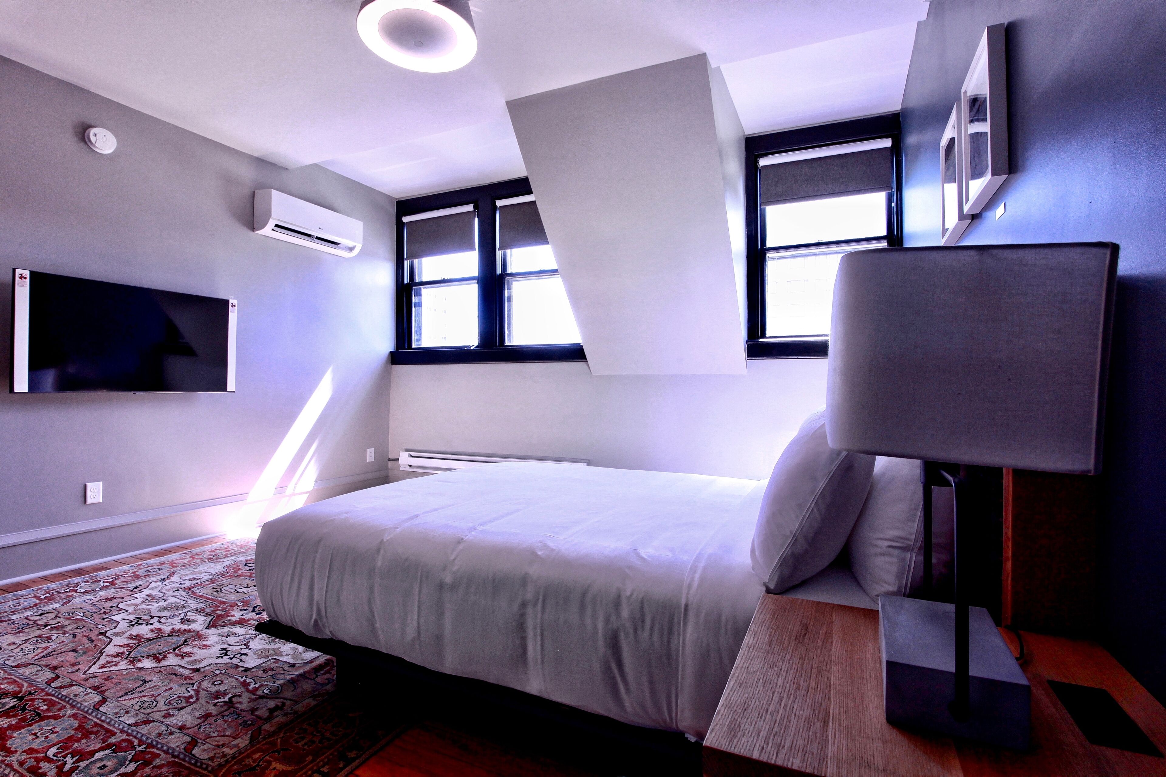 Una camera da letto moderna con un grande letto, una televisione a schermo piatto e una finestra con vista.