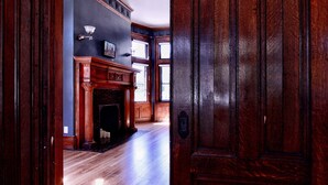 A grand hallway with a wooden door, a fireplace, and a staircase leading to an upper level. - Dubbel Dutch (Milwaukee)