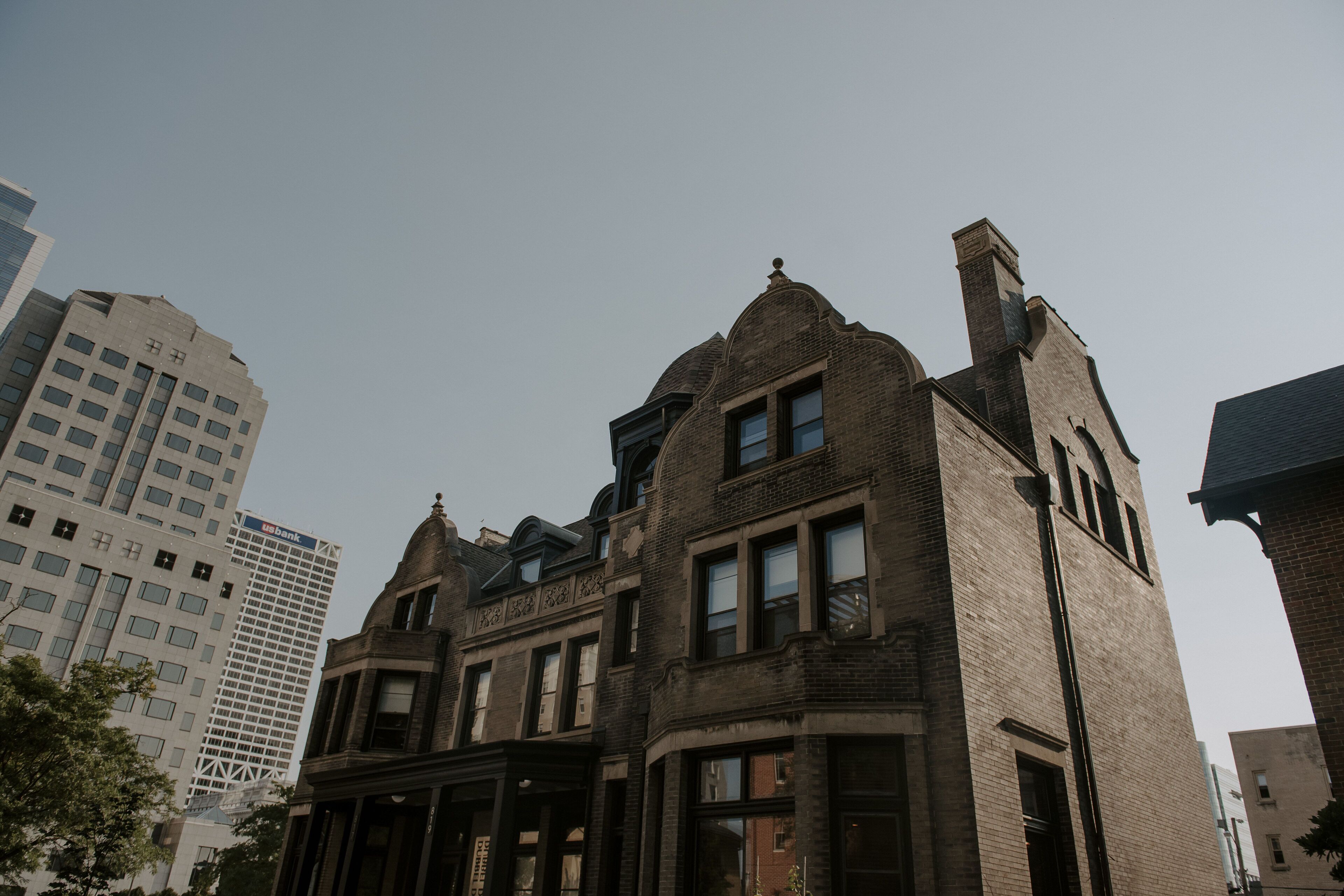 A historic building with a prominent corner turret and large windows.