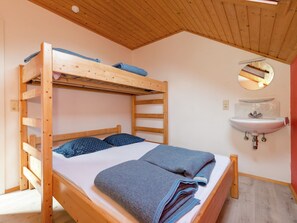 A bunk bed with a wooden frame, a white sink, and a mirror above it. - Holiday Home in Deiffelt Near Forest (Gouvy)