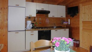 Una cocina compacta con armarios de madera, horno integrado y lavamanos.