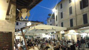 An outdoor dining area with tables and chairs, surrounded by buildings. - Peaceful Stay With Garden (Alto Reno Terme)