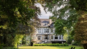 A large, multi-story house with a prominent balcony and a well-maintained lawn. - Beautiful Castle in Spa wit Garden (Spa)