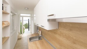 Een moderne keuken met witte kastjes, een houten aanrecht en een roestvrijstalen spoelbak.