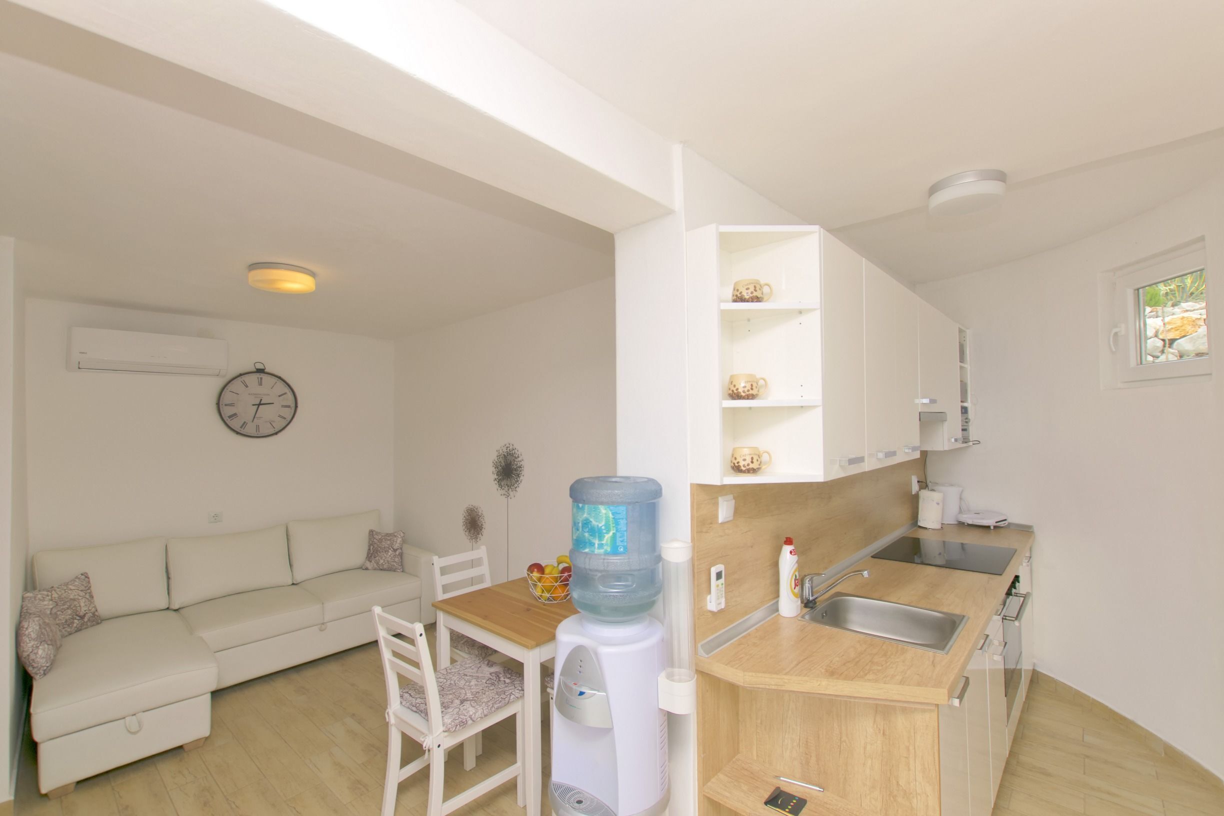 Un espace de vie compact comprenant une kitchenette, un coin repas et un canapé.