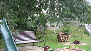 Ein Spielplatz mit Rutsche, Schaukeln und Sandkasten.