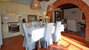 A dining area with a brick archway, white tablecloths, and chairs. - Villa in Cortona With Pool & Countryside Views (Cortona)
