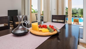 A dining table with a cheese platter, a knife, and glasses. - Peaceful Home in Policnik (Policnik)