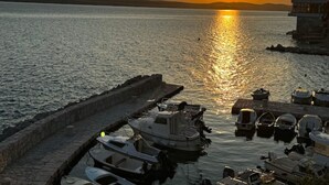 Um porto ao pôr do sol, com barcos atracados no cais.