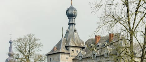 A historic stone building with a prominent tower and a smaller spire.