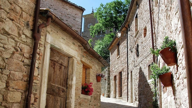 A narrow stone alleyway with traditional stone buildings, wooden doors, and potted plants. - Belvilla by OYO Sogno (Piobbico)