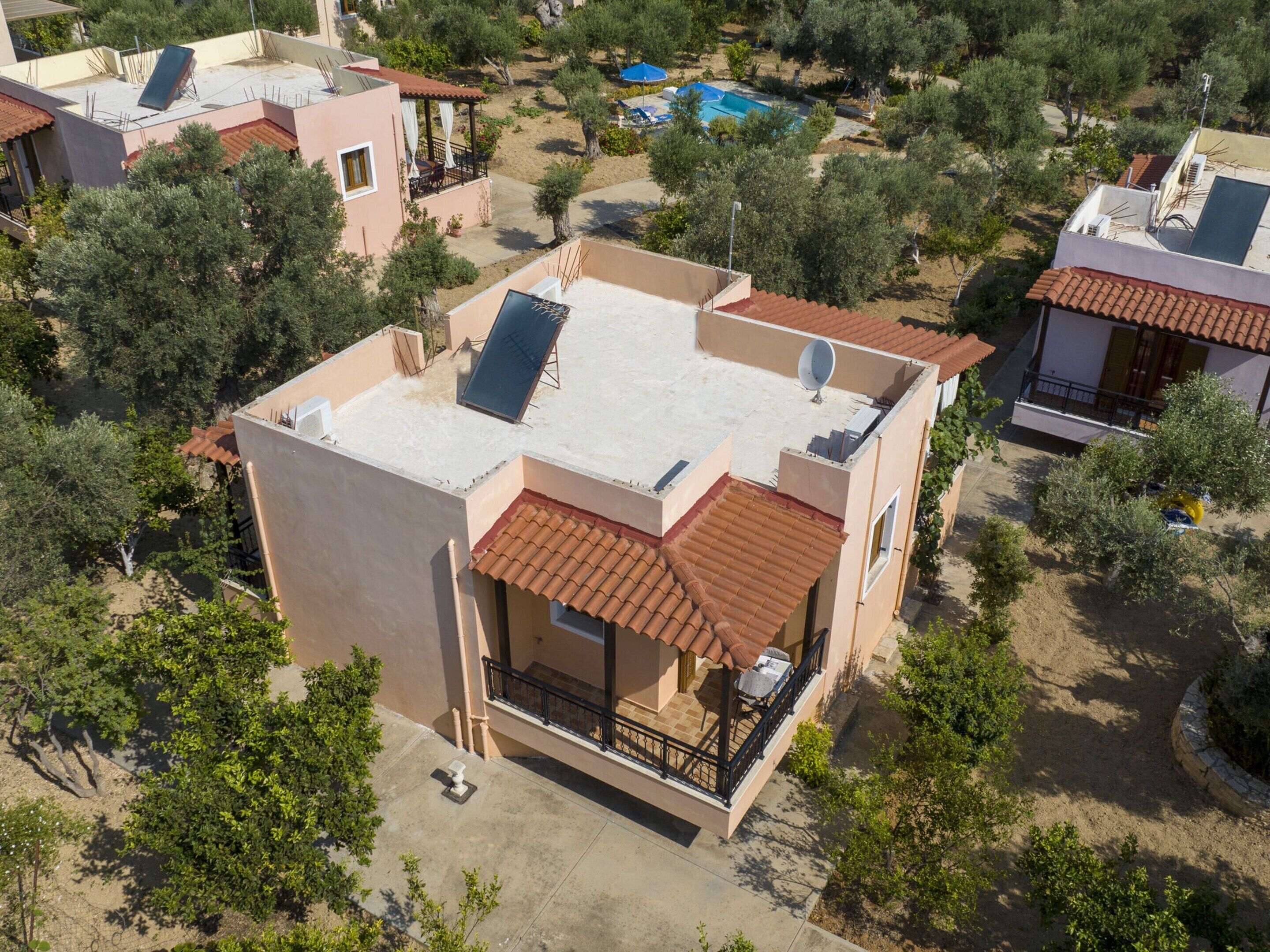 Un edificio residenziale con tetto piatto, antenna parabolica e un balcone con mobili da esterno.