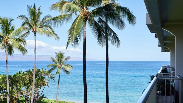 A balcony with a view of the ocean and palm trees. - AEI at The Whaler Kaanapali Beach Resort (Lahaina)