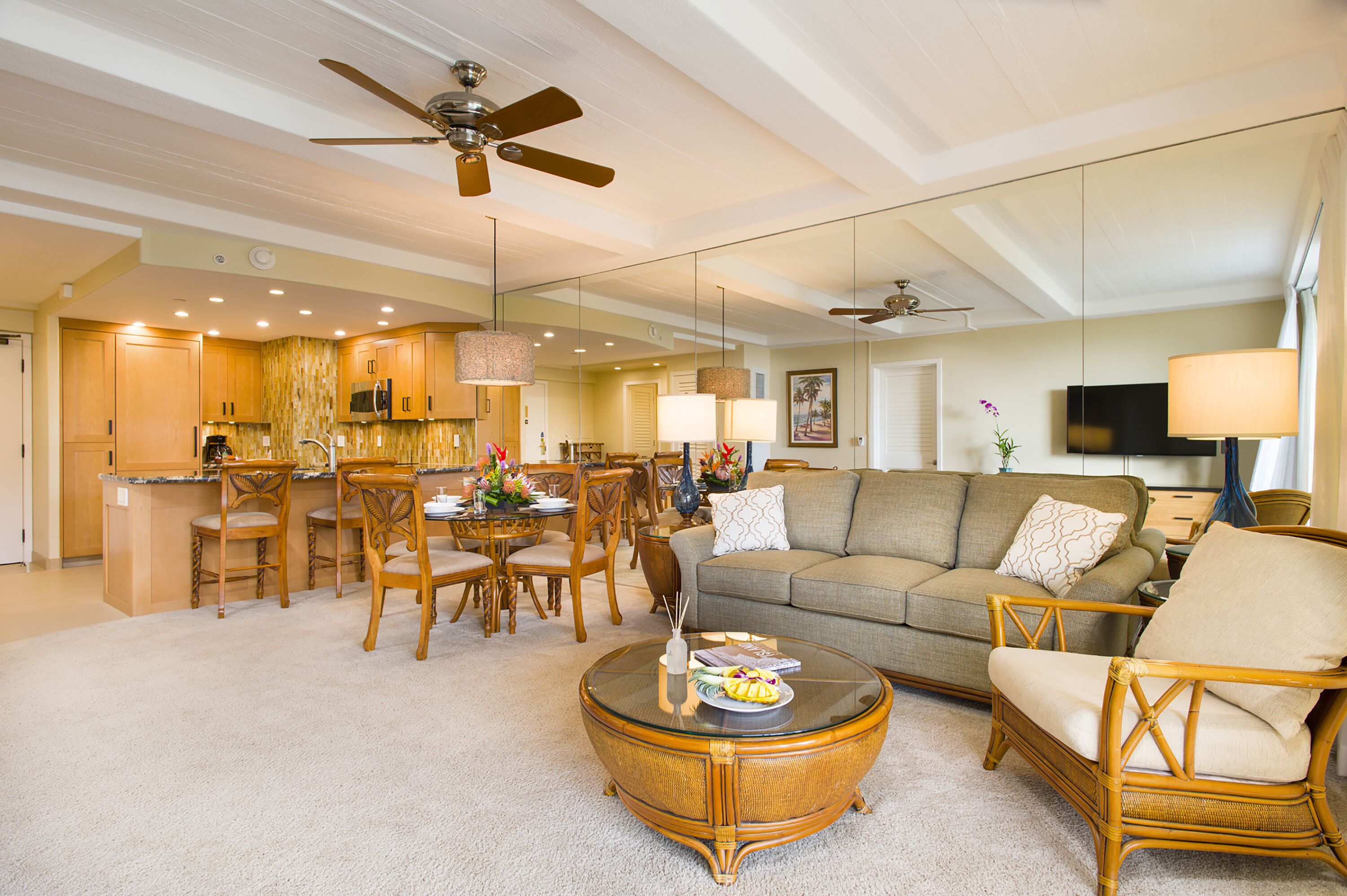 A spacious living room with a large sofa, a coffee table, and a dining area with chairs and a table.