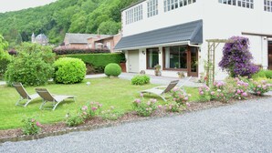 A modern two-story house with a well-maintained garden, including a lawn, shrubs, and flowering plants. - Luxurious Holiday Home in Hamoir With Terrace (Hamoir)