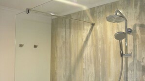 A shower with a rain shower head and a handheld showerhead, mounted on a wall with a textured, light-colored finish. - Luxurious Holiday Home in Hamoir With Terrace (Hamoir)
