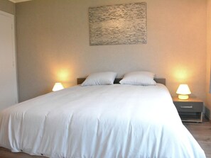 A neatly made bed with white linens, two bedside lamps, and a painting on the wall. - Luxurious Holiday Home in Hamoir With Terrace (Hamoir)