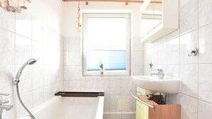 Badkamer | Een bad, een haardroger, handdoeken