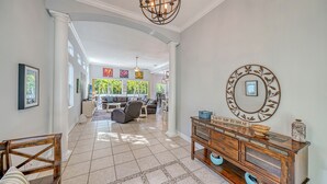 A spacious living area with a modern design, featuring a large dining table, comfortable seating, and a decorative wall piece. - Siesta Soul | Multilevel Home Located in Siesta Key Village w/ Private Pool, Fire Pit, Walk to Beach (Siesta Key)