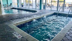 An indoor swimming pool with a tiled floor, clear water, and a 'No Diving' sign.