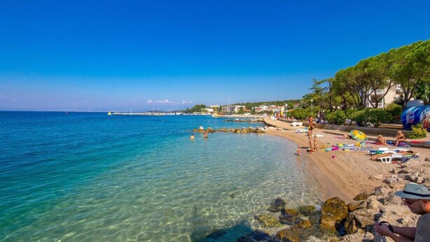 A beach with clear waters, rocky shoreline, and people relaxing. - Apartment With Terrace, Sea View, Pool & Outdoor Kitchen (Malinska-Dubasnica)