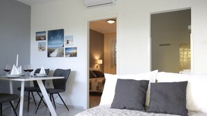 A hotel room with a bed, a dining table with chairs, and a small kitchenette. - Scenic Holiday Home in Bibinje near Sea (Bibinje)