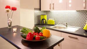 A kitchen with a black and white checkered backsplash, a yellow kettle, and a sink.