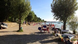 A beach with people, boats, and trees. - Residence near Lake Garda (Lazise)