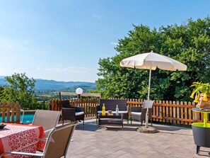 An outdoor patio with a pool, wicker furniture, and a view of mountains. - Countryside Home in Arezzo With Pool (Arezzo)