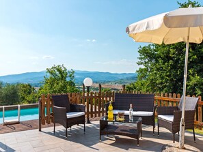 An outdoor patio with wicker furniture, a pool, and a scenic view of mountains. - Countryside Home in Arezzo With Pool (Arezzo)
