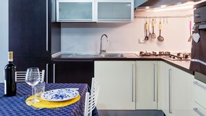 A modern kitchen with dark cabinets, a stainless steel sink, and a hanging utensil rack. - Countryside Home in Arezzo With Pool (Arezzo)
