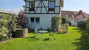 A two-story house with a garden, a lawn, and a table with chairs. - Modernes Ferienhaus mit Garten in Kagsdorf (Bastorf)