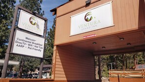 A Ventura Grand Inn sign with amenities like continental breakfast, DirectTV, WiFi, hot tub, AARP, and pet-friendly services. - Ventura Grand Inn (Mammoth Lakes)