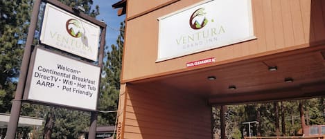 A Ventura Grand Inn sign with amenities like continental breakfast, DirectTV, WiFi, hot tub, AARP, and pet-friendly services.