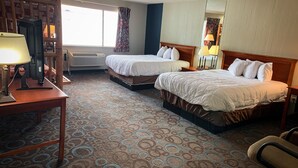 A hotel room with two beds, a desk, a chair, a TV, and a window with curtains. - Ventura Grand Inn (Mammoth Lakes)