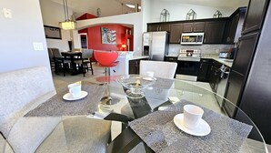Una cucina moderna con mobili scuri, un frigorifero in acciaio inossidabile e un forno a microonde.