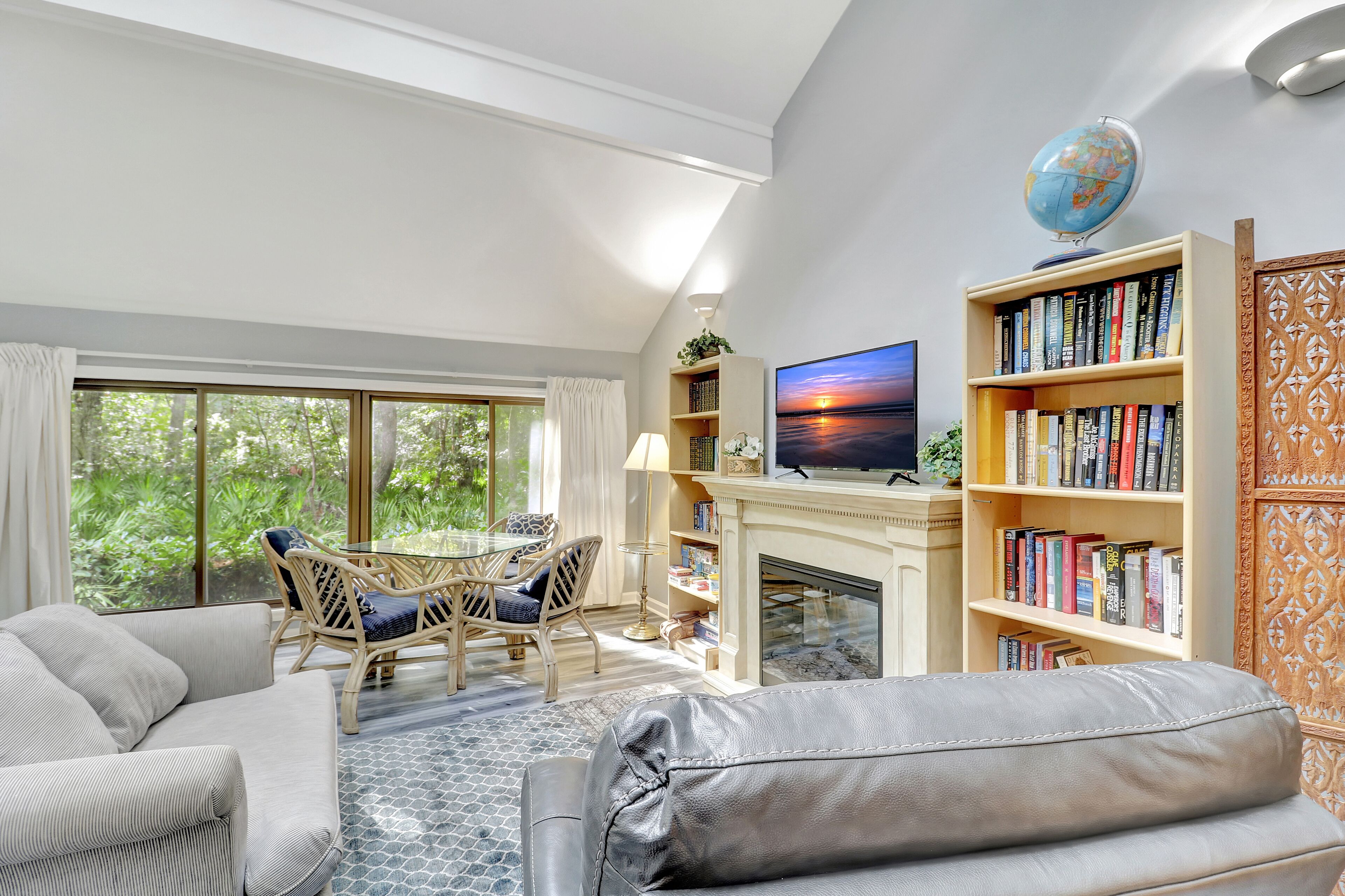 A living room with a sofa, a coffee table, a fireplace, a bookshelf, and a TV.