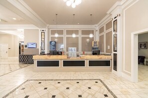 A reception area with a marble floor, a reception desk, and a large window.